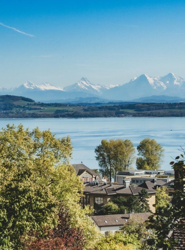 a town by the water with mountains in the background